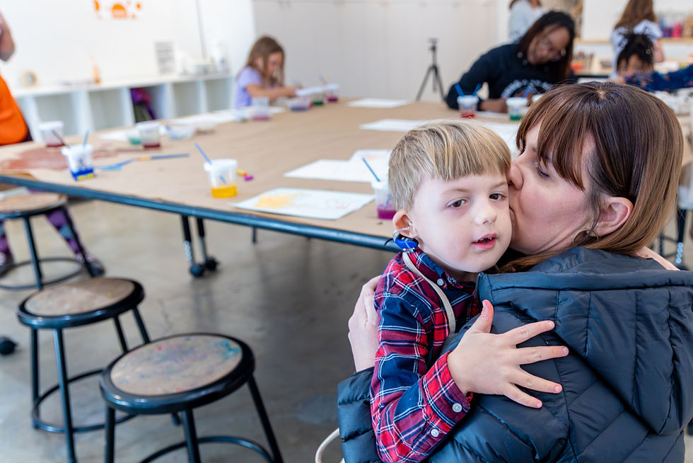 Una mamá abrazando a un niño pequeño.