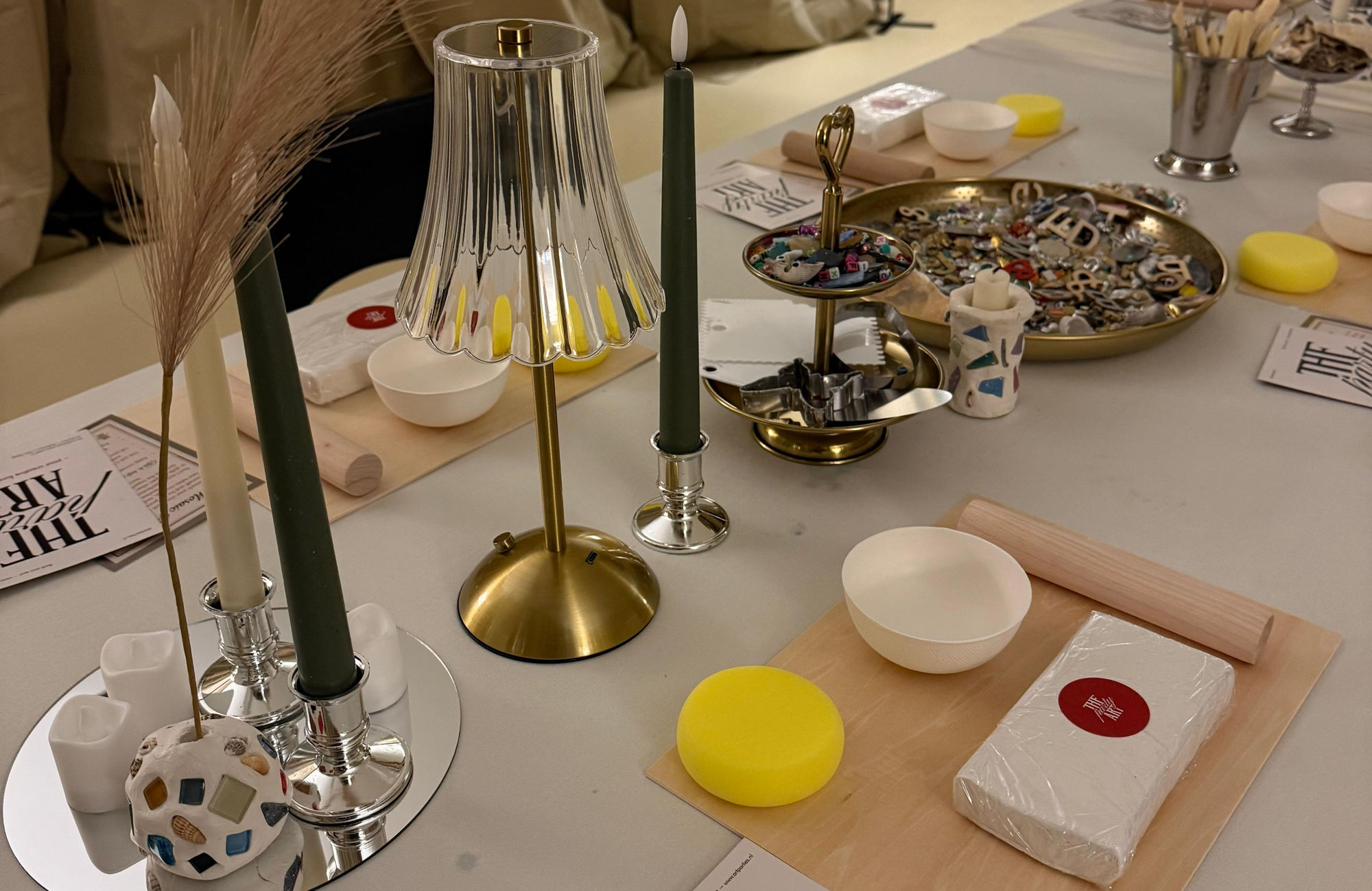 A long candlelit table set for a workshop at the ARTparty studio