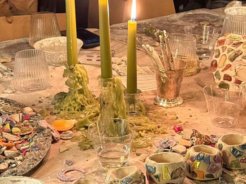 Finished mosaic pieces on a candlelit table at the ARTparty studio