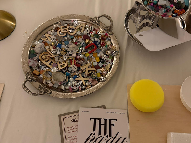 Trays of mosaic tiles, shells and charms on a workshop table
