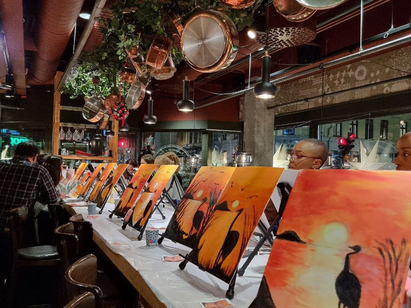 A long row of easels with finished sunset paintings