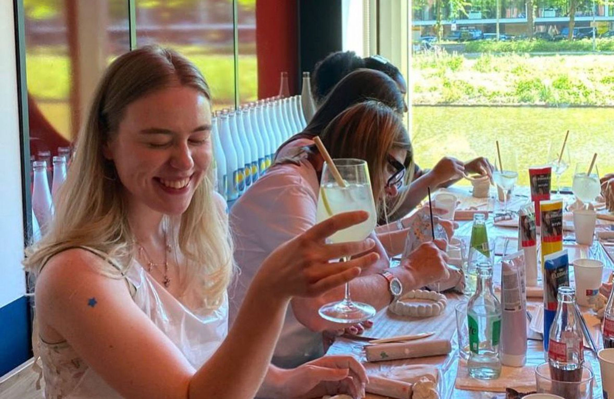 Friends raising a glass during a painting workshop