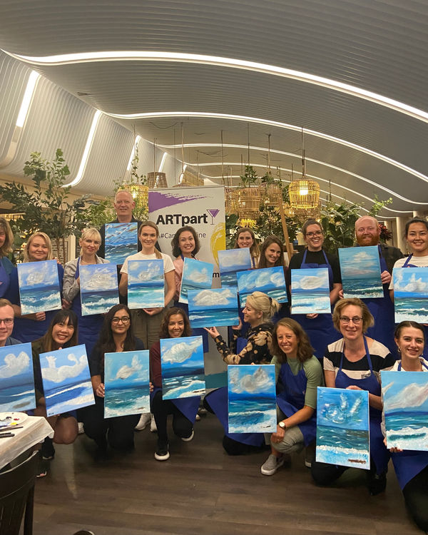 A company group with their finished paintings