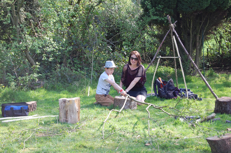 Mother and son working together to saw wood