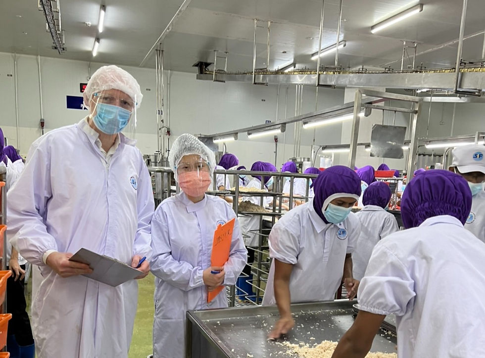 Inspectors in protective gear at a food processing plant.