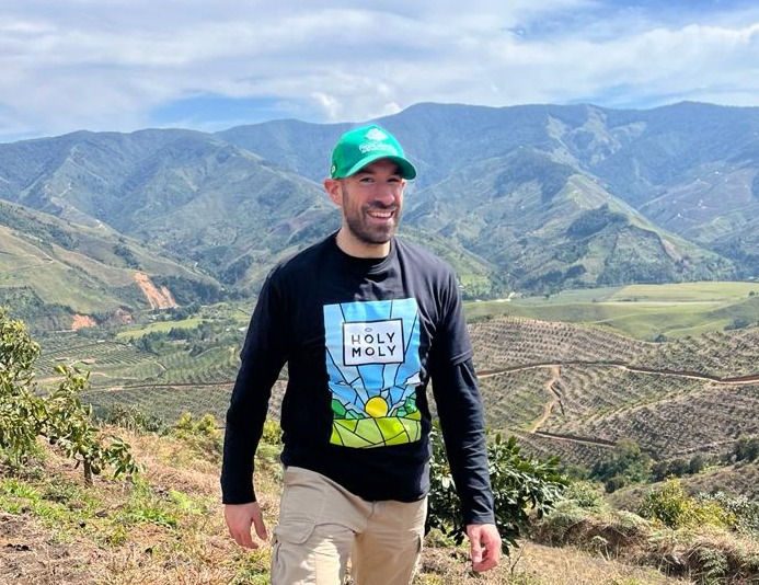 Smiling man in Holy Moly shirt in a mountain valley