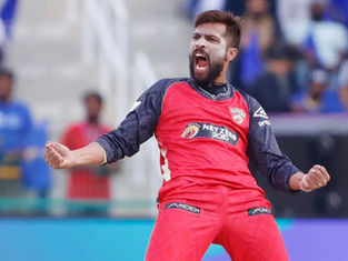 Pakistani fast bowler Mohammad Amir celebrates a wicket passionately during an ILT20 match while wearing his team’s red and black kit.