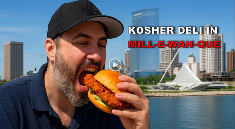 Man eating a kosher deli sandwhich in front of the Milwaukee skyline