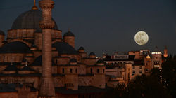 Full moon rises next to Istanbul's Yeni Mosque.
