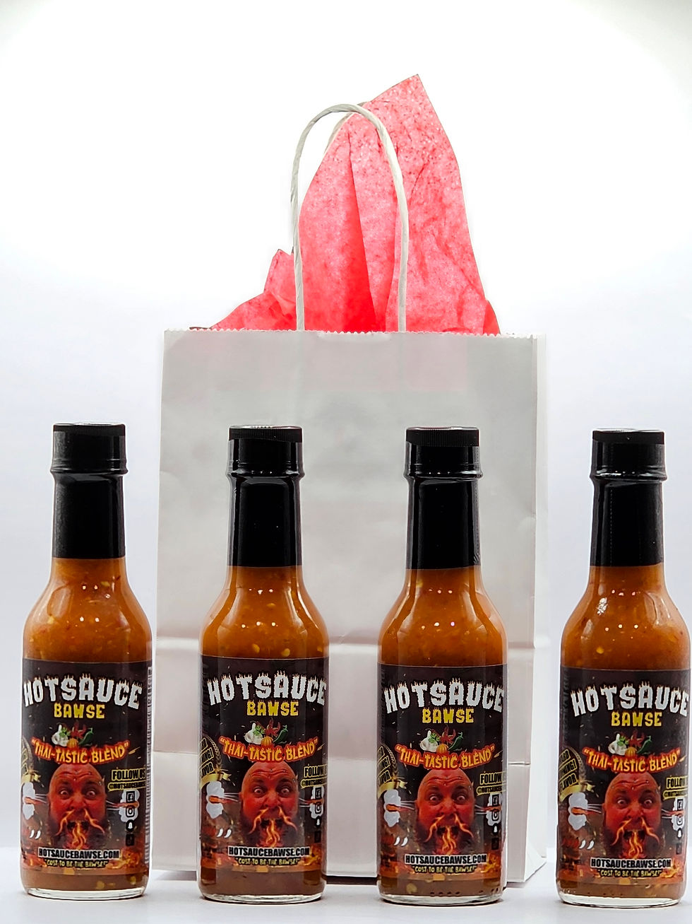 Close-up view of colorful hot sauce bottles lined up on a wooden table