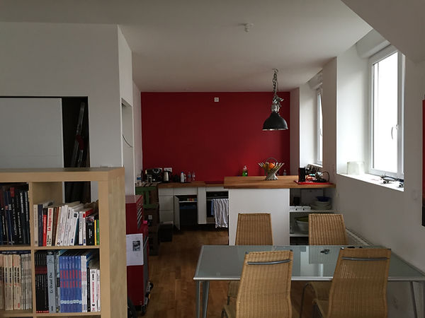 Pièce de vie ouverte avec poutres apparentes dans un appartement rénov