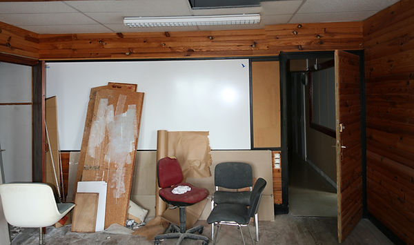 Anciens bureaux avant transformation en appartement à Vannes : lambris en pin, faux plafond en dalles et éclairage au néon
