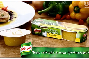 Pacote e pote de caldo de galinha Knorr sobre mesa de madeira. Prato de comida e legumes ao fundo. Texto: "Toda refeição é uma oportunidade".