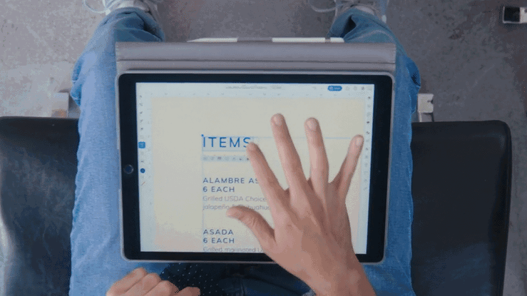 Man walking with iPad towards restaurant