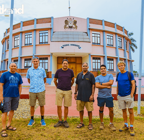 Hutland Tours group of travellers posing in front of the Tooro Kingdom palace building in Fort Portal, Uganda