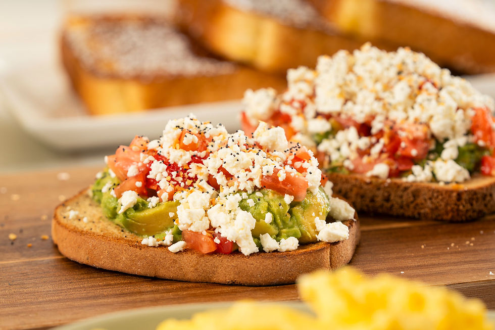 Avocado toast topped with diced tomatoes, crumbled feta, and everything seasoning on hearty toasted bread