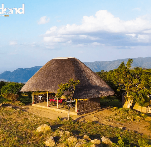 Large thatched open-air dining and communal area with panoramic mountain views at Kara Tunga Safari Camp, Kidepo Valley National Park, Uganda