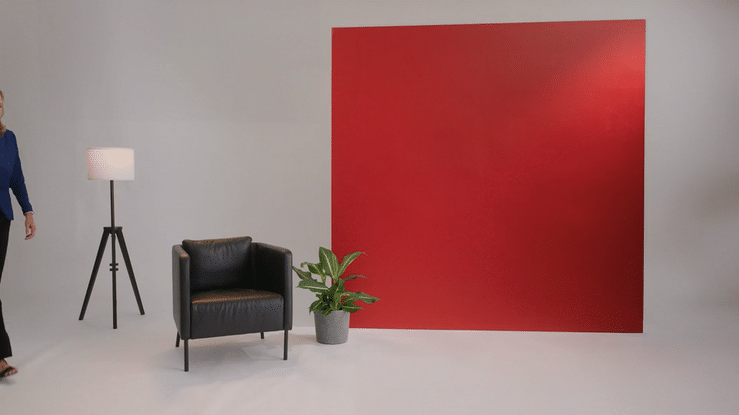 Woman sitting down with red backdrop