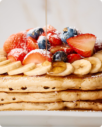 Keke's Breakfast Cafe Florida Pancakes topped with fresh strawberries, blueberries, bananas, and warm syrup