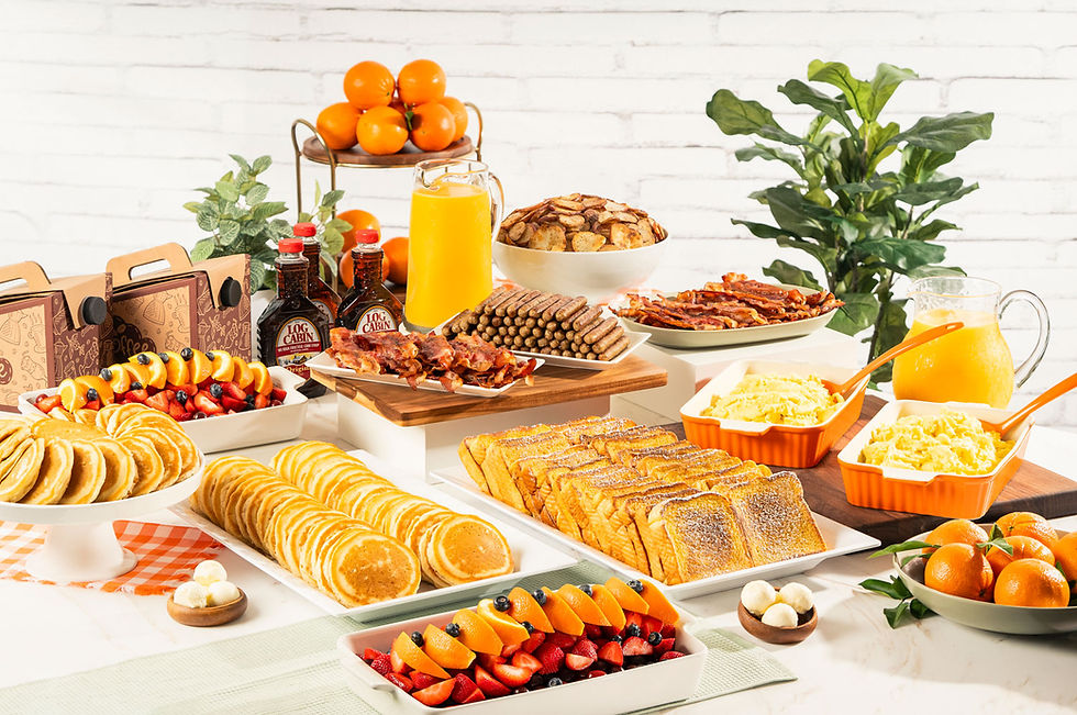 Full Keke's breakfast catering spread with pancakes, French toast, eggs, bacon, sausage, potatoes, fruit, and juice