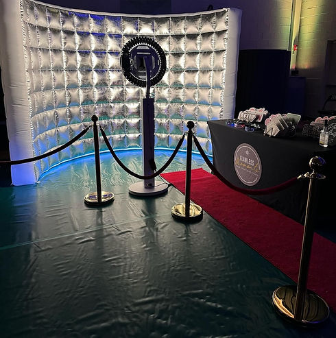 Photo booth setup with red carpet and large light