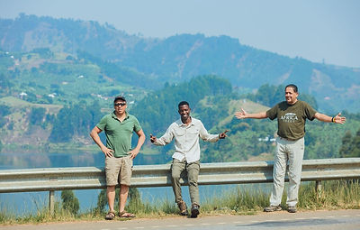 Three men standing overlooking hill in Kenya