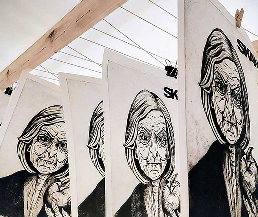 Art prints drying on a rack