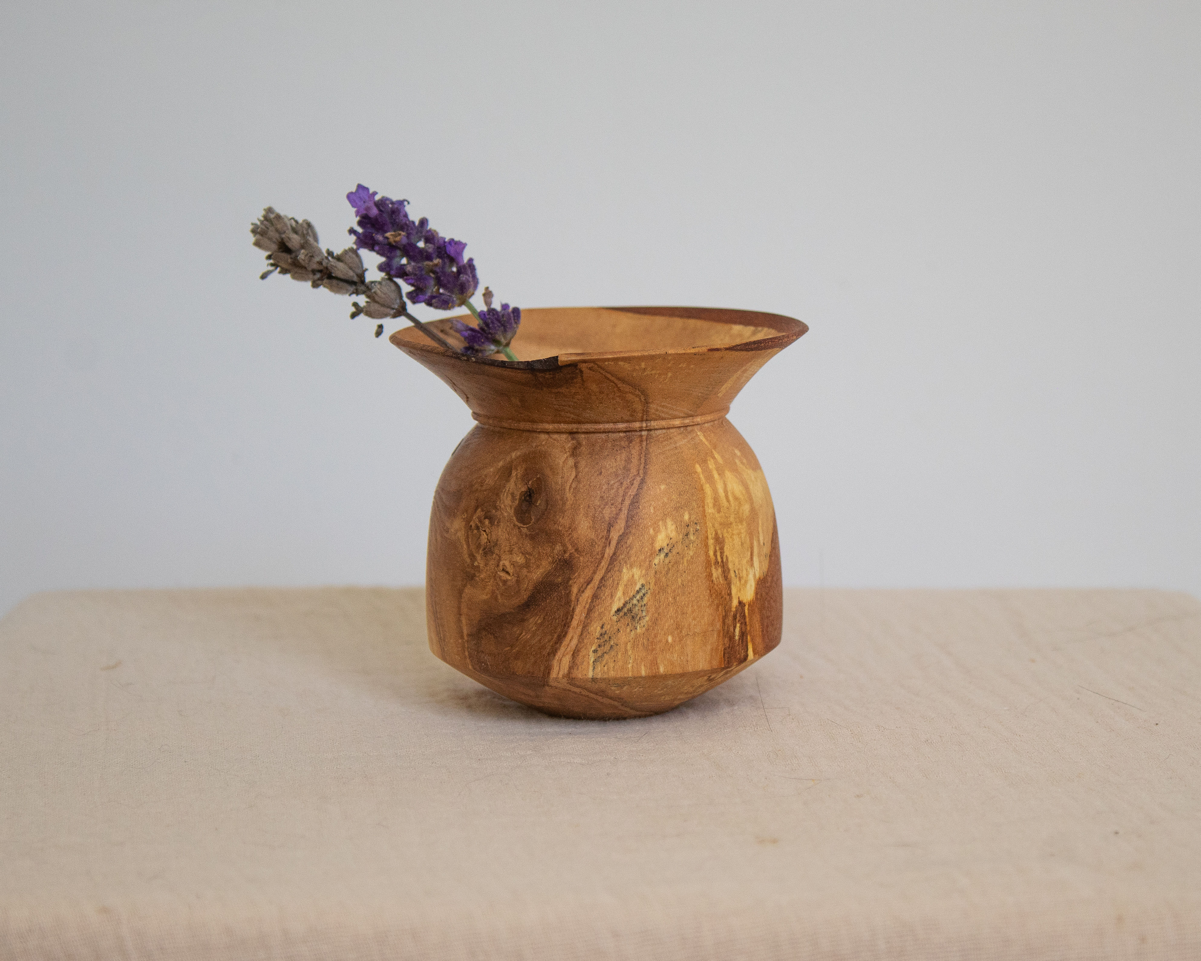 small wooden ash vessel with dried flowers