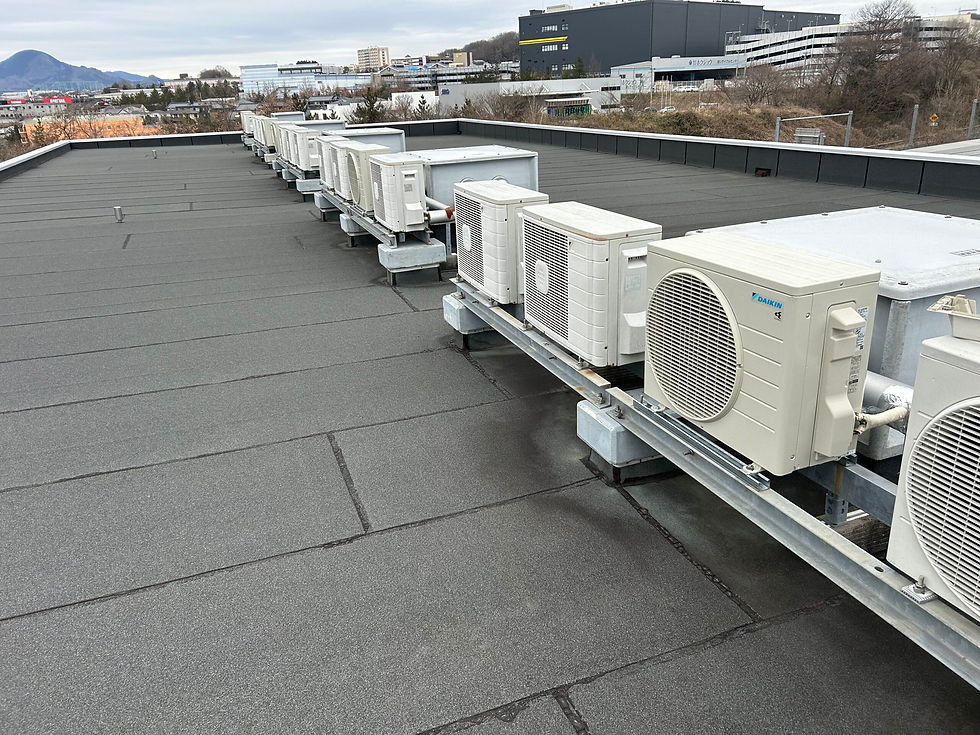 High angle view of a technician installing an air conditioner unit on a commercial building