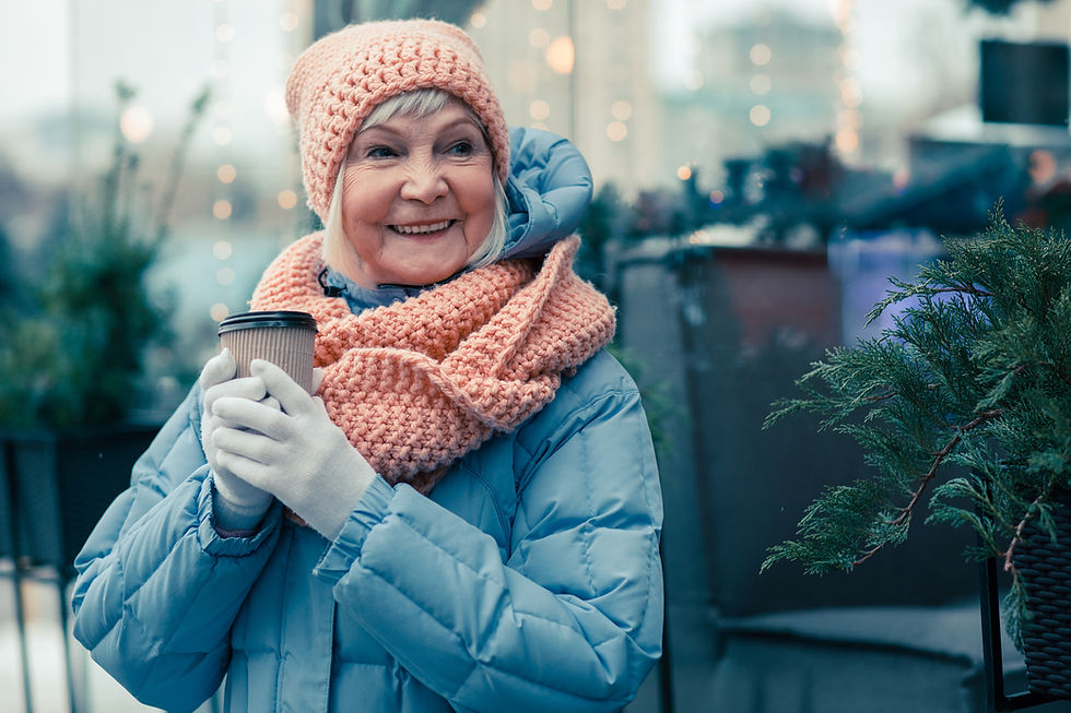 older woman drinking coffee in a parka outsside
