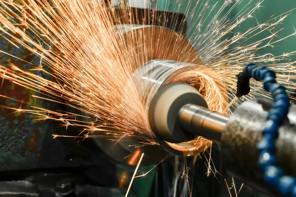 A roughing grinding abrasive wheel machining a cylindrical part highlighting professional grinding services in a tool-room