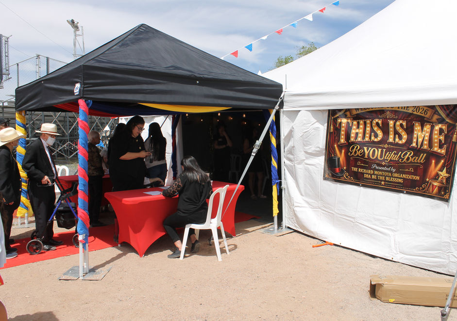 Outdoor event with two tents, people, and 'THIS IS ME' banner