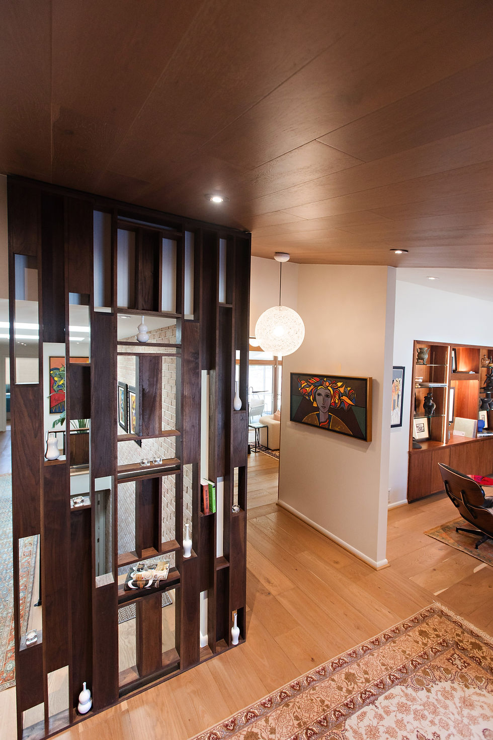 Custom walnut room divider framing the living area of the Emory Village residence in Atlanta.