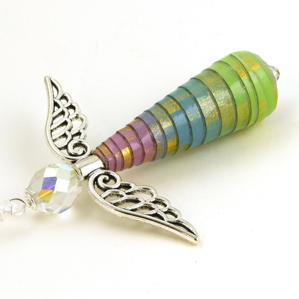 Thumbnail: Purple, Blue, and Green paper bead angel ornament laying diagonally, head first, on a white background.