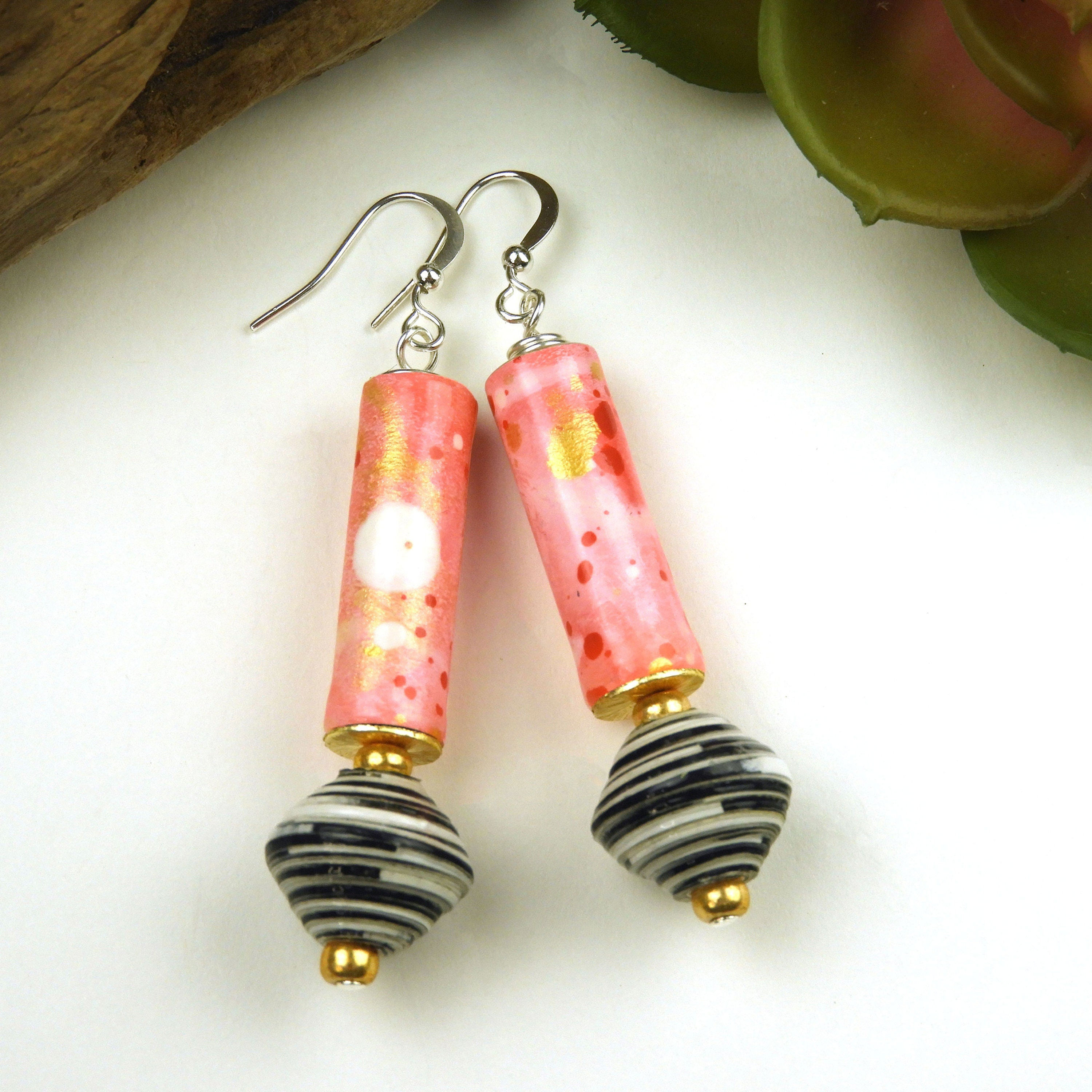 Pink, gold, black, and white paper bead earrings on a white background.
