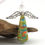 Thumbnail: Orange, green, blue, and gold abstractly painted paper bead angel ornament standing in front of a piece of driftwood.