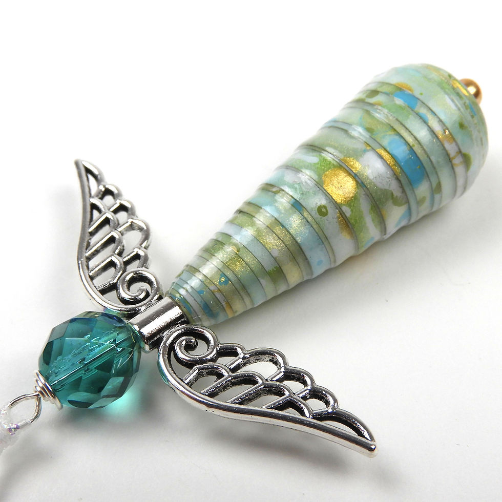 Thumbnail: Blue, green, white, and gold paper bead angel ornament laying diagonally on a white background.
