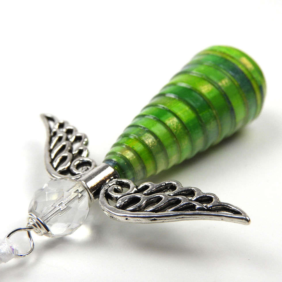 Shades of green paper bead angel ornament laying diagonally, head first, on a white background.