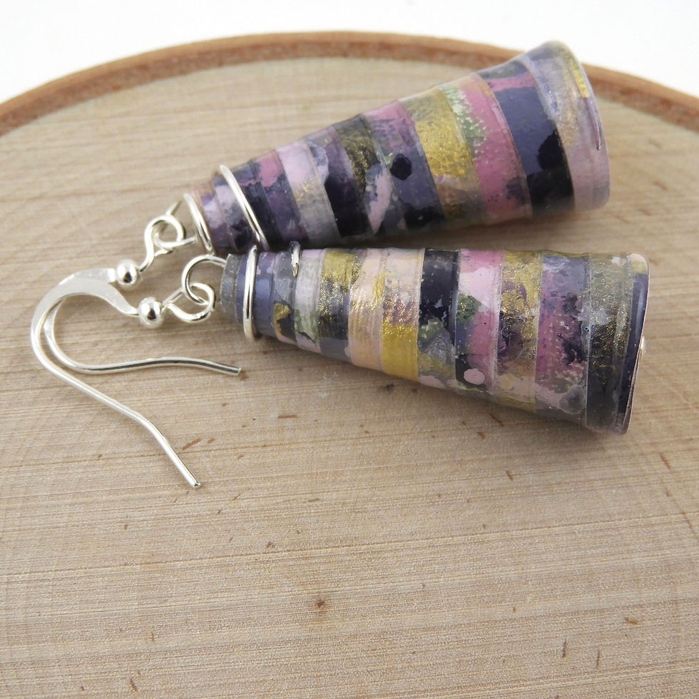 Thumbnail: Shades of purple and gold paper bead earrings on a wood background.