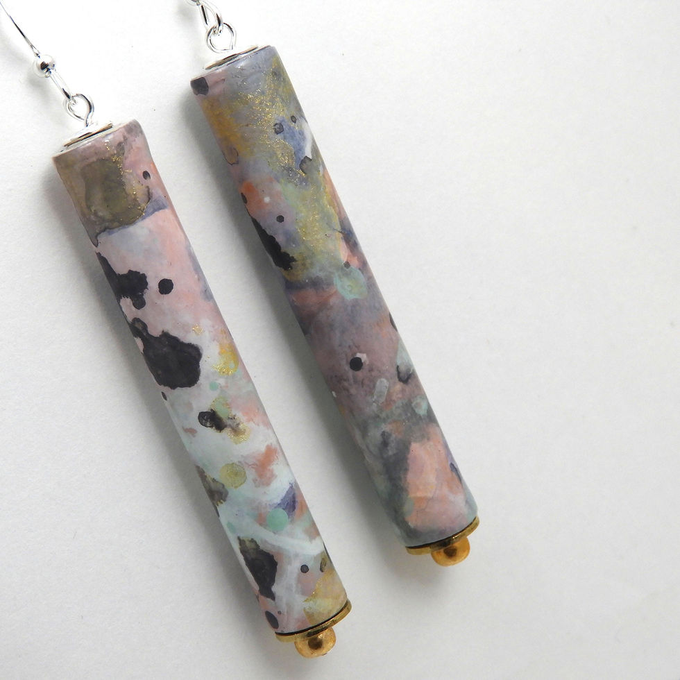 Thumbnail: Gray, pink, aqua, and gold abstractly painted paper bead earrings hanging on a white background.
