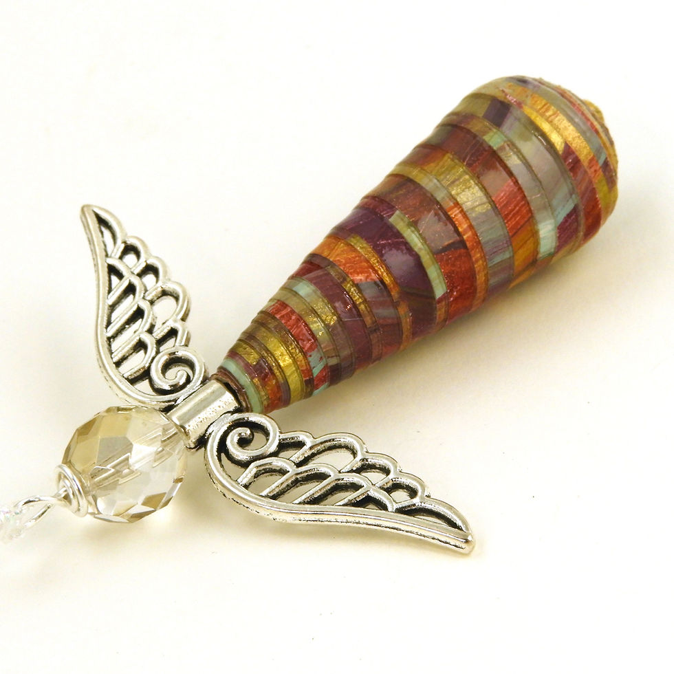 Thumbnail: Autumn colors paper bead angel ornament laying diagonally, head first, on a white background.