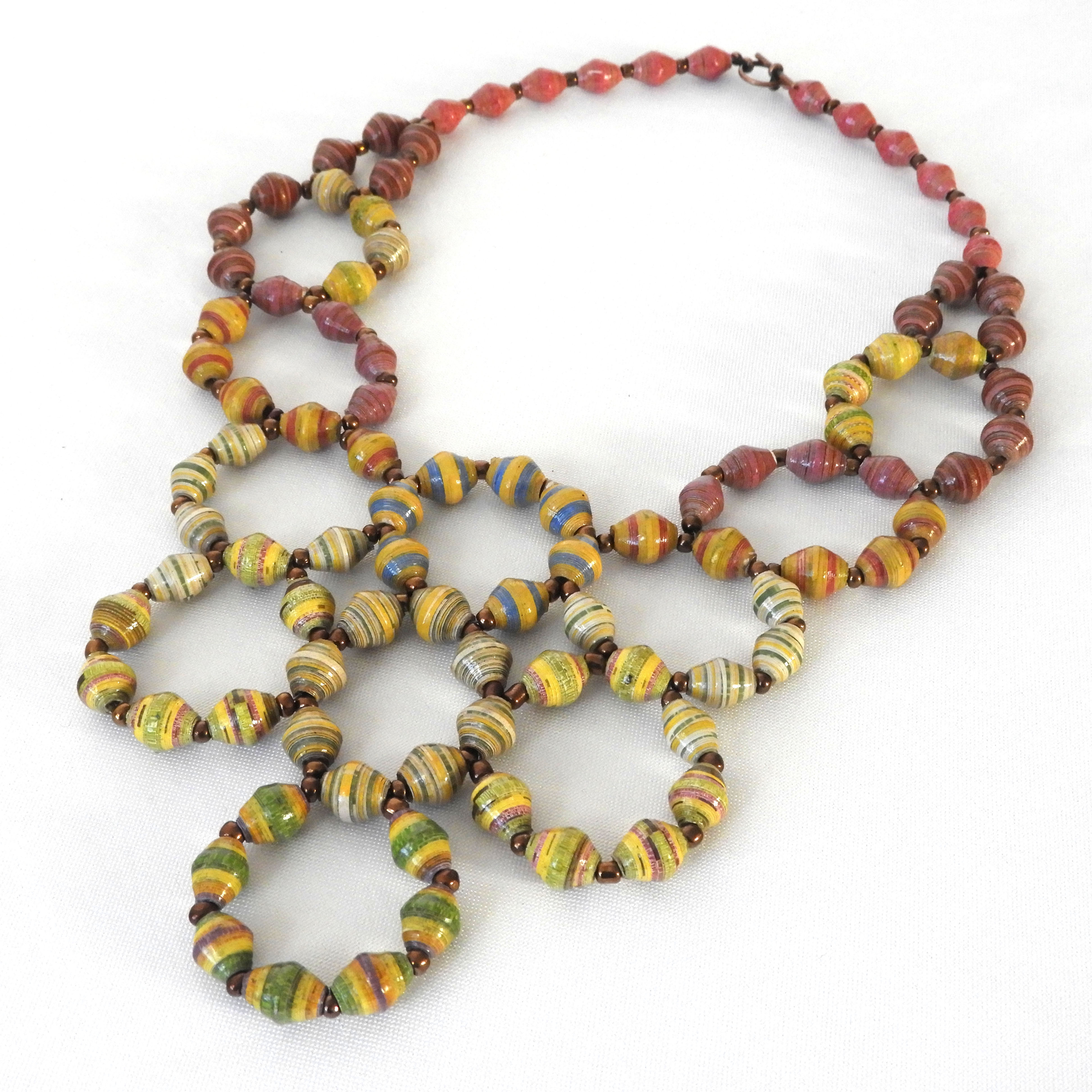 Green, yellow, and pink paper bead bib necklace on a white background.