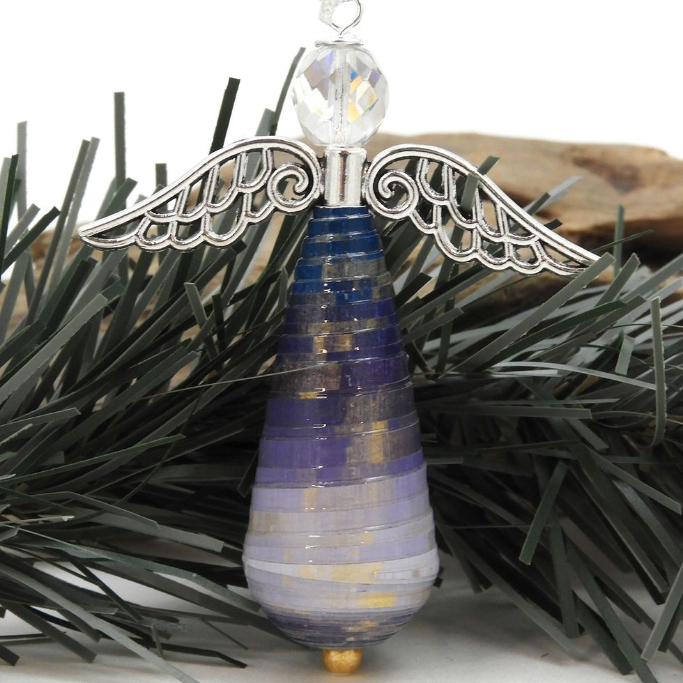 Thumbnail: Purple ombre paper bead angel ornament standing in front of a piece of Christmas tree garland.