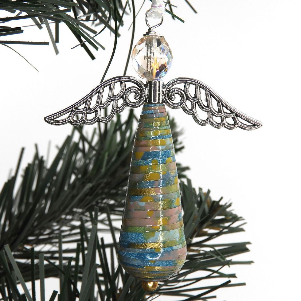 Thumbnail: Green, teal, pink, gold, and blue paper bead angel ornament hanging from a Christmas tree.