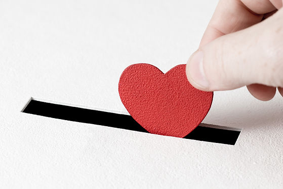Red heart symbol is put by person's hand