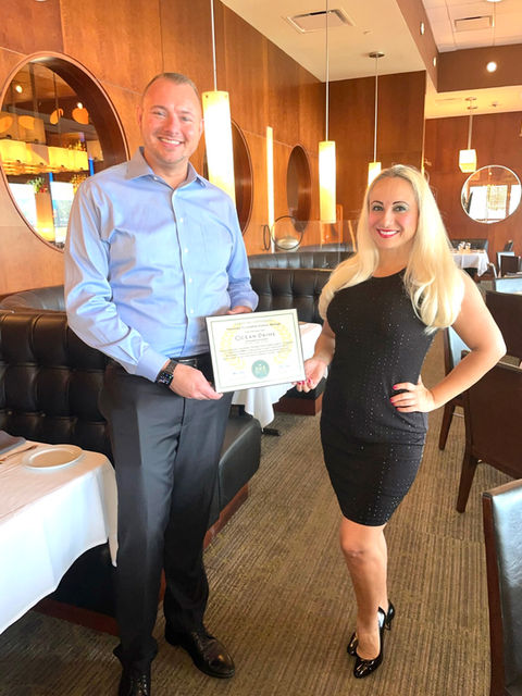 Alicia Valdes Providing Plaque of Honor to Jonathan Pollock with Ocean Prime for Earth Day