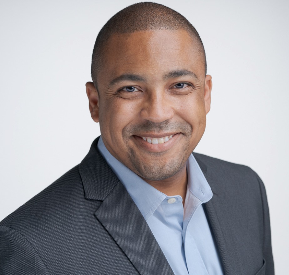Professional portrait of Rolondo Talbott in a gray suit and blue shirt
