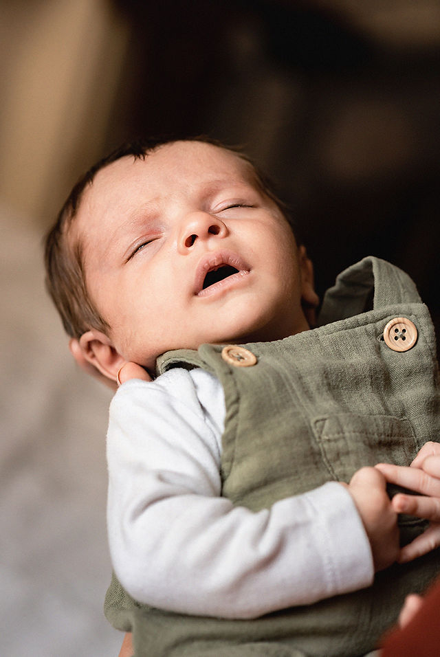 Photographie d'un portrait d'un petit bébé dans les bras de sa maman réalisée par une photographe professionnelle naissance lyonnaise lors d'une séance photo famille à la Croix-Rousse à Lyon