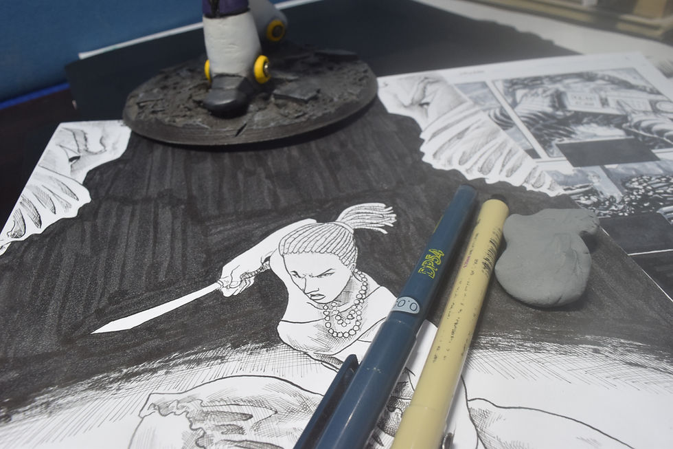 Comic artist workspace with traditional tools and sketches