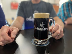 Beer customer holding stout in mug.jpeg